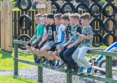 Group of boys sitting on a fence in Mellowes Adventure Centre for kids Meath